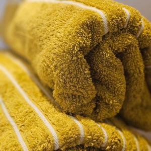 a pile of yellow towels with white stripes at Kerikeri Blue Chair B&B in Kerikeri