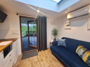 sala de estar con sofá azul y ventana en La'al Lodge in Kendal (The Gateway to the Lakes) en Kendal