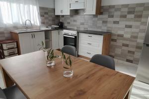 a kitchen with a wooden table with two vases on it at Dafnonas House - Bright & Modern in Leonidion