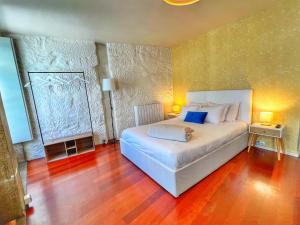 1 dormitorio con cama blanca y almohadas azules en São Domingos Residences I, en Oporto