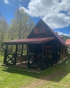 eine Hütte mit einem Gameradach auf einem Grasfeld in der Unterkunft Puhova Koliba in Delnice