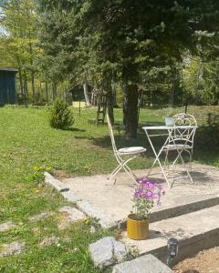 une chaise et une table dans la cour dans l'établissement Puhova Koliba, à Delnice