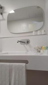 un lavandino in bagno con specchio e asciugamano di Ruta Jacobea a Lavacolla