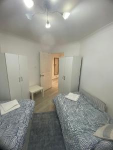 een kleine kamer met 2 bedden en een kamer met een bed. bij 2 bedroom apartment in Maida Vale in Londen