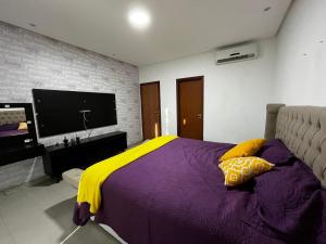Casa Amsterdam في لورو دي فريتاس: غرفة نوم بسرير كبير مع بطانية صفراء