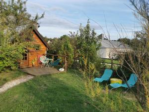 a cabin with a deck and chairs in the yard at La bulle des champs in Champmotteux +8 photos