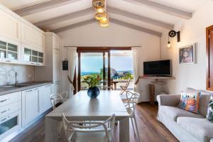 a kitchen and living room with a table and chairs at villa Le farfalle in San Teodoro