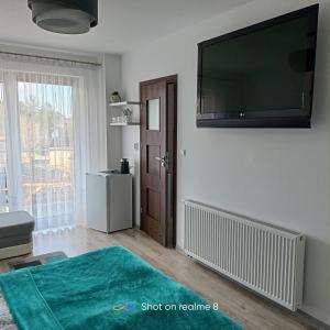 Una sala de estar con un televisor de pantalla plana en una pared. en Villa Turkus, en Jastrzębia Góra