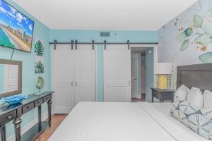 a bedroom with a white bed and blue walls at The Palace 2110 in Myrtle Beach