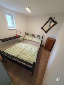 a bedroom with a bed and a mirror and a window at "Bedroo 2" Ferienwohnung am historischen Hafen in Wanfried