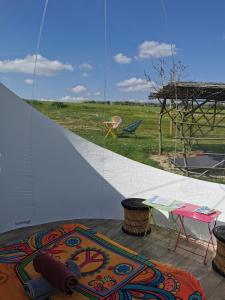 a rug on a patio with a table and a view at La bulle des champs in Champmotteux