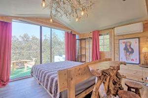 una camera da letto con un letto e una grande finestra di incroyable cabane perchée avec spa et vue panoramique au calme Le Mas des faraches a Solliès-Toucas