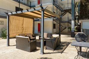um pavilhão com cadeiras e um grelhador em frente a um edifício em Your 2B Getaway Steps to Dtwn - Sleeps 6 - Pool, Prkg em Austin