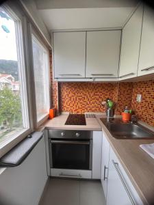 een keuken met witte kasten en een wastafel bij Apartman Centar in Tivat