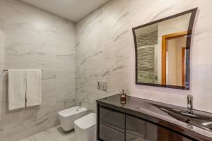 a bathroom with a toilet and a sink and a mirror at Porta 116 in Vila Real