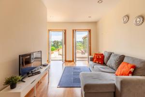 a living room with a couch and a flat screen tv at Porta 116 in Vila Real