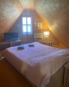 um quarto com uma cama grande num sótão em Puhova Koliba em Delnice