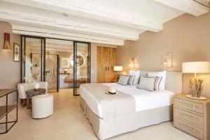 a bedroom with a large white bed and a desk at La Bastide Saint Georges & Spa in Forcalquier