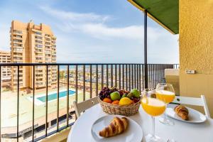 a table with a basket of fruit and wine glasses on a balcony at Paseo Marítimo Rey de España in Fuengirola