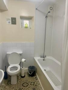 a bathroom with a toilet and a tub and a sink at Prestashortstays in Belfast