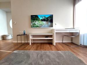 a living room with a white desk with a tv on the wall at Hanza Tower STETT-INN Business & Holiday in Szczecin