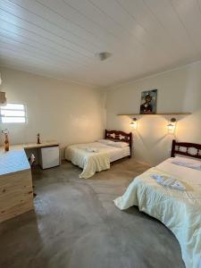 um quarto com duas camas num quarto em Pousada Vila do Penedo em Penedo