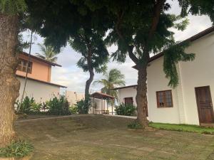 una casa con dos árboles delante de ella en Morro Branco Suítes - Hospedaria Morro Branco, en Beberibe