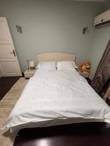 sypialnia z dużym białym łóżkiem z białą pościelą w obiekcie Unique apartment in Almaza w Kairze