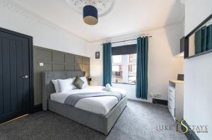 a bedroom with a bed and a large window at Luke Stays - Granville Street in Gateshead