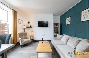 a living room with a white couch and a green wall at Luke Stays - Granville Street in Gateshead