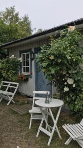zwei weiße Stühle und ein Tisch vor einem Haus in der Unterkunft Villa Lavendel in Borgholm