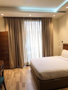 um quarto com uma cama e uma grande janela em UDS Villa Scandinavian B&B - Next to VFS em Nova Deli
