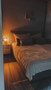 ein Schlafzimmer mit einem Bett und einem Nachttisch mit einer Lampe in der Unterkunft Wohlfühlapartment in Wassernähe in Oderberg