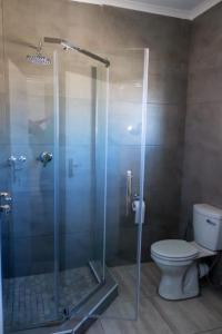 a bathroom with a glass shower with a toilet at Serene Stay Guesthouse in Letlhakane