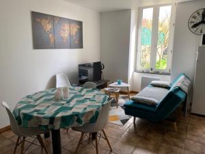 Très bel appartement avec jardin et Jacuzzi في Scey-sur-Saône-et-Saint-Albin: غرفة معيشة مع طاولة وأريكة