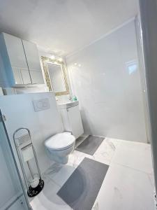 a white bathroom with a toilet and a mirror at Apartment Harmony in Graz