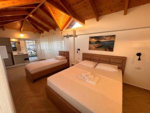 una camera con due letti in una stanza con soffitti in legno di Villa Memaj a Ksamil