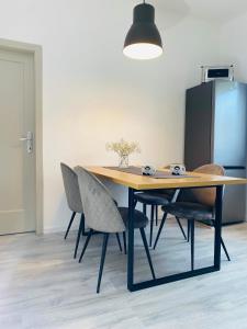 - une table à manger avec des chaises et un réfrigérateur noir dans l'établissement Apartma Srečko, Sežana, à Sežana