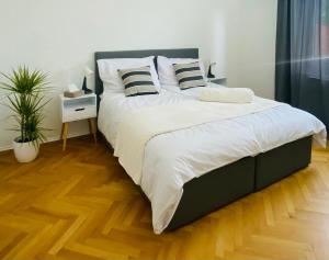- une chambre dotée d'un grand lit avec des draps et des oreillers blancs dans l'établissement Apartma Srečko, Sežana, à Sežana