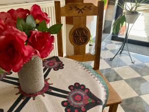 扎科帕內的住宿－Pokoje Gościnne Wilga，一张桌子上装满红玫瑰的花瓶