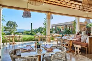 a restaurant with tables and chairs and a large window at La Bastide Saint Georges & Spa in Forcalquier