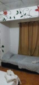 een slaapkamer met 2 stapelbedden en een gordijn bij Ofiuras Hostal in Colón