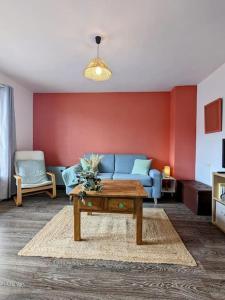 ein Wohnzimmer mit einem blauen Sofa und einem Tisch in der Unterkunft The place to be, parking gratuit in Roanne