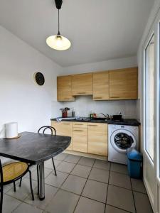 eine Küche mit einem Tisch und einer Waschmaschine in der Unterkunft The place to be, parking gratuit in Roanne