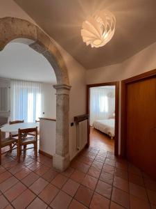 a room with a table and a bed and a chandelier at Appartamento Brione Lido in Nago-Torbole +5 photos
