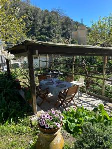een patio met een tafel, stoelen en bloemen bij La casa nel verde in Lavagna