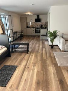 sala de estar con suelo de madera y cocina en Ferienwohnung Ambiente 1, en Naumburg