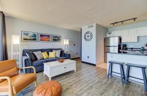 a living room with a couch and a kitchen at 0510 Beachtrippin' home in Carolina Beach