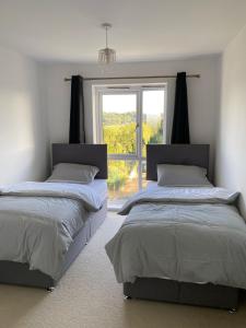 2 camas en una habitación con ventana en Home Stay en Belvedere