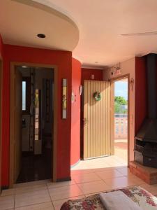 a living room with red walls and a door at Pousada Krolow in Pelotas